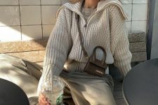 20 a grey t-shirt, a creamy chunky knit lapel sweater, grey trousers, black chunky shoes, a small bag