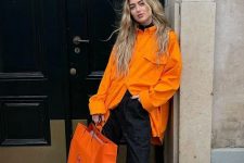 24 a black turtleneck, an orange oversized shirt, black jeans, orange boots and an orange bag