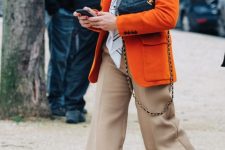 26 a bright fall look with a white t-shirt, a printed scarf, an orange blazer with pockets, tan trousers and white trainers