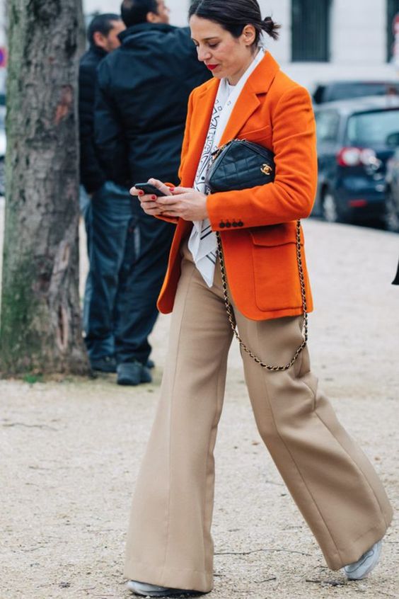 a bright fall look with a white t shirt, a printed scarf, an orange blazer with pockets, tan trousers and white trainers