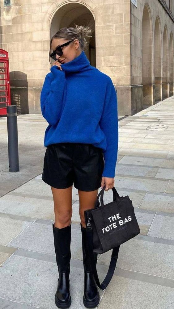 a bold fall look with an electric blue sweater, black leather shorts, black knee chunky boots and a black tote