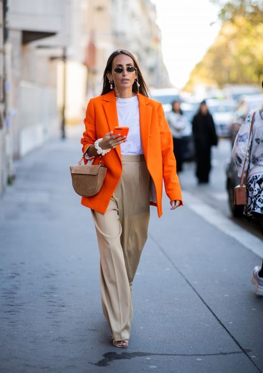 a lovely work outfit with a white t-shirt, an orange oversized blazer, tan high waisted pants, a brown mini bag