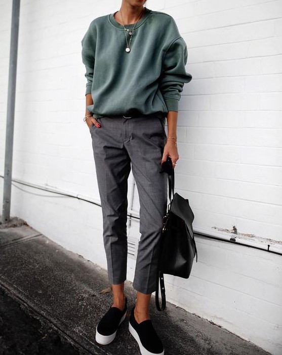 an olive green sweatshirt, cropped grey trousers, black slipons and a black backpack for the fall