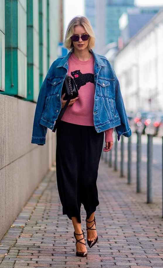 a black midi skirt, black strappy shoes, a pink printed jumper, a blue denim jacket and a black bag for a bright look