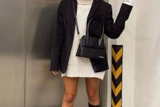 31 a white chunky knit sweater dress, an oversized black blazer, black chunky knee boots, a black bag create a contrasting fall look
