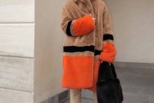 With brown, orange and black knee-length faux fur coat and beige leather over the knee boots