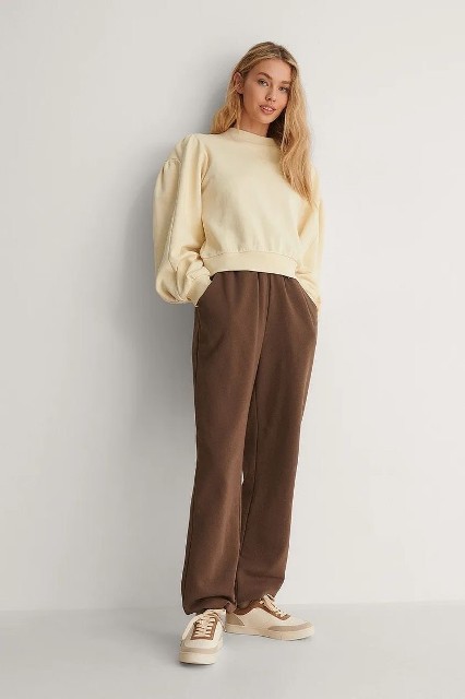 With brown sporty pants and beige and brown lace up flat shoes