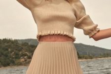 With gray wide brim hat and beige high-waisted pleated midi skirt