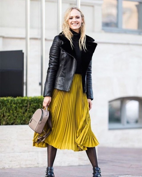 With mustard yellow pleated midi skirt, beige leather backpack and black leather embellished boots