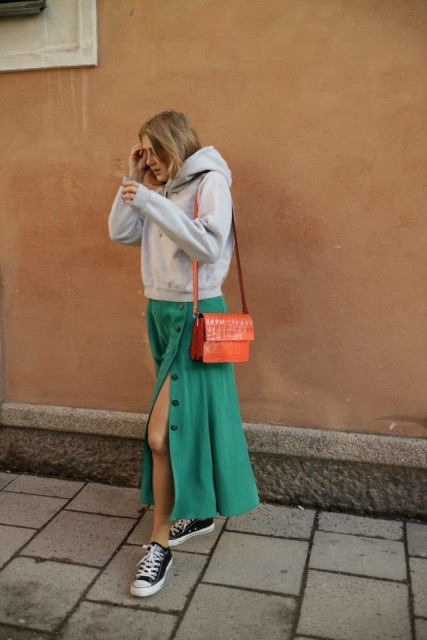With orange leather bag and black and white sneakers