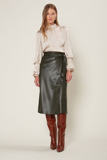 With pastel colored satin bell sleeved blouse and brown leather high boots