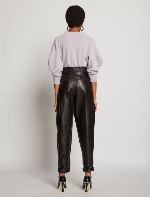 With rounded earrings, dark brown leather high-waisted cuffed trousers and black leather high heels