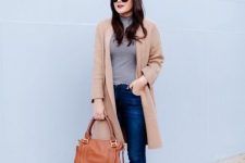 With sunglasses, navy blue skinny jeans, brown leather tote bag and brown ankle boots