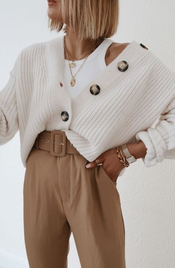a beautiful neutral outfit with a white top, a creamy chunky cardigan, layered necklaces and beige high waisted pants