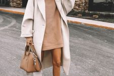 a beige sweatshirt mini dress, a white trench, nude Chelsea boots and a beige bag to rock this fall