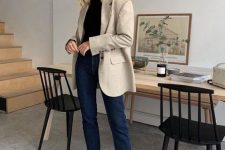 a black turtleneck, navy jeans, an oversized neutral blazer and black man-style shoes for a fall look