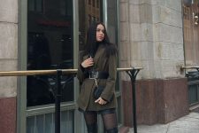 a black turtleneck,a black mini skirt, black tights and over the knee boots, a dark green oversized blazer and a black bag