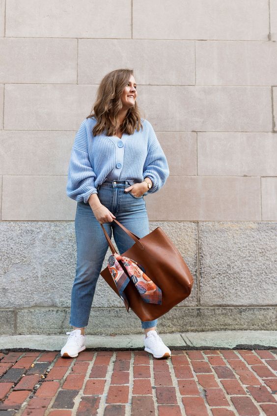a blue chunky knit cardigan, blue cropped jeans, white trainers, a brown tote for a simple and cool fall work look