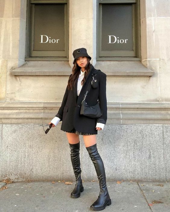 a catchy fall outfit with a white shirt, printed shorts, black over the knee boots, a black blazer and a small black bag