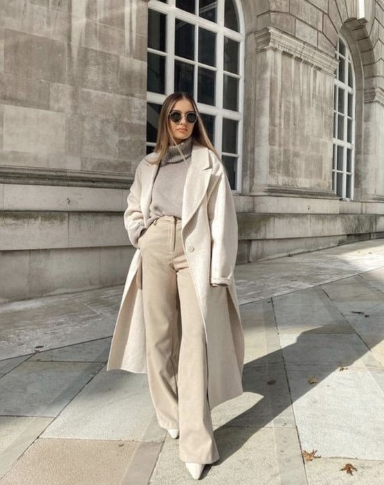 a chic all-neutral outfit with a grey turtleneck, creamy pants, a creamy midi coat, white booties for late fall or winter