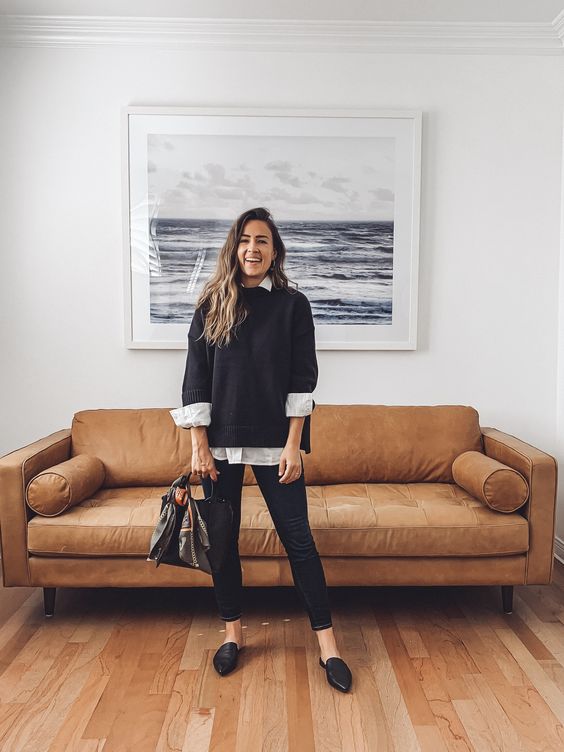 a cool fall work outfit with an oversized white shirt, a black jumper over it, black leather pants, black slipper mules and a black bag