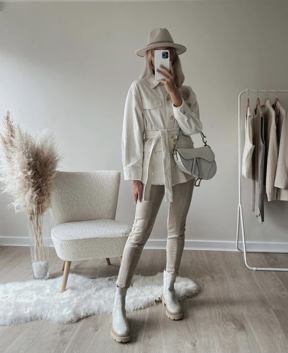 a creamy shirtjacket, off-white leather leggings, nude Chelsea boots, a creamy hat and a white saddle bag