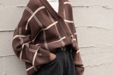 a fall work look with a white turtleneck, a brown printed oversized cardigan, black jeans, a brown belt and a bucket hat