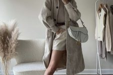 a grey top, creamy shorts, a grey suede trench, nude Chelsea boots, a neutral hat and a white bag