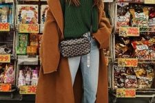 a lovely fall outfit with a green turtleneck sweater, blue jeans, green sneakers, a brown coat and a black printed bag
