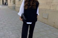 a monochromatic outfit with a white shirt, a black waistcoat, black trousers, black loafers and a bag for work
