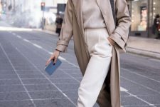 a neutral and comfy outfit with a ribbed sweater, creamy sweatpants, nude boots, a neutral leather trench and a black bag