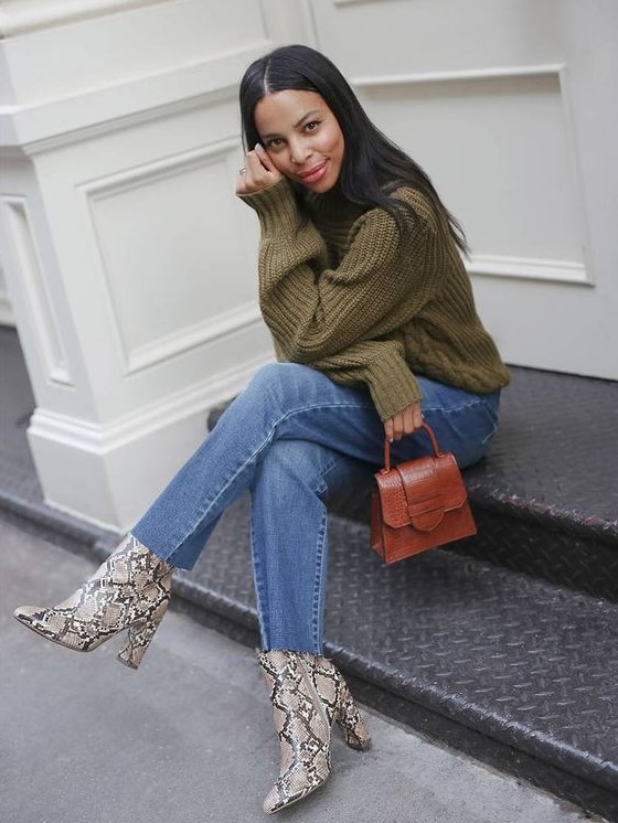 a pretty fall-colored outfit with a green chunky sweater, blue jeans, snakeskin print booties and a rust-colored mini bag