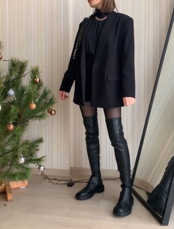 a sexy total black look with a mini skirt, a turtleneck, a blazer, over the knee boots, a chain necklace and a small bag