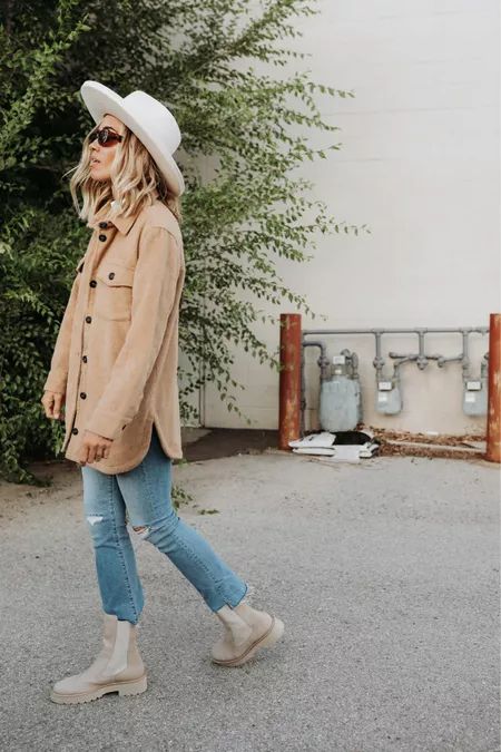 a white t-shirt, a tan shirt jacket, blue cropped and ripped jeans, nude chelsea boots and a white hat