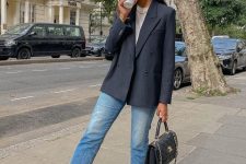 a white t-shirt, blue cropped jeans, a black striped blazer, a black bag and black Converse sneakers for a more relaxed work look