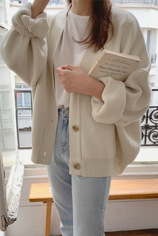 a white t-shirt, light blue jeans, an oversized creamy cardigan with cuffed sleeves for a casual or work outfit
