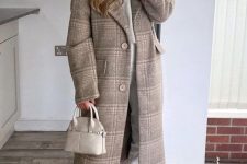 a white top, white cropped jeans, nude Chelsea boots, a beige printed coat and a tiny neutral bag