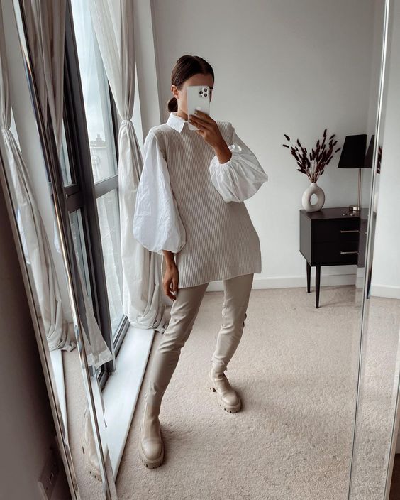 an all-neutral fall outfit with a white shirt with puff sleeves, a ribbed waistcoat, creamy leather pants, creamy Chelsea boots