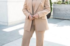 an all-neutral fall work outfit with a beige pantsuit, flare pants, a matching turtleneck and grey shoes