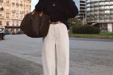 an oversized black sweater, white baggy jeans, leopard print shoes, a brown belt and a brown printed bag