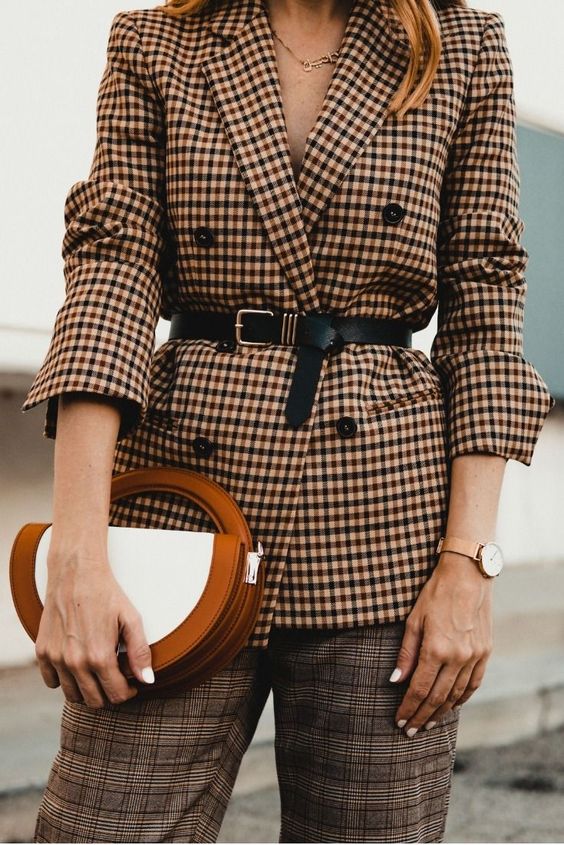grey plaid trousers paired with beige plaid blazer with a black belt and a chic semi circle bag plus a beige watch