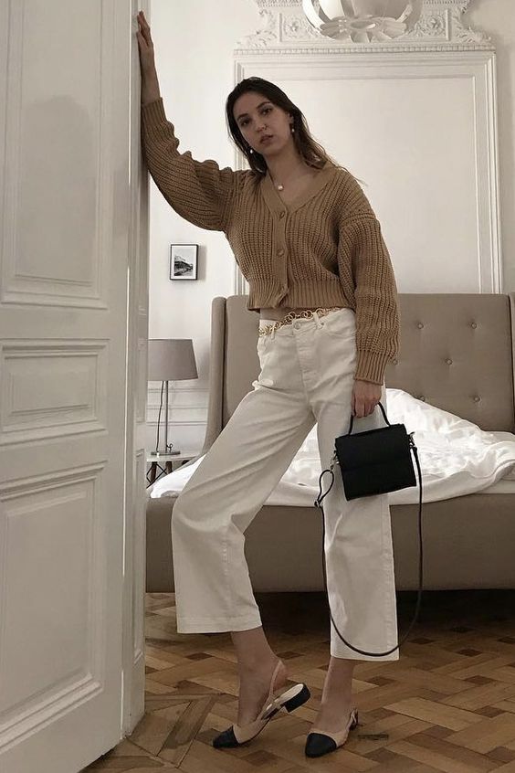 a chic Parisian look with a beige chunky cropped cardigan, white cropped jeans, two-tone slingbacks and a black bag