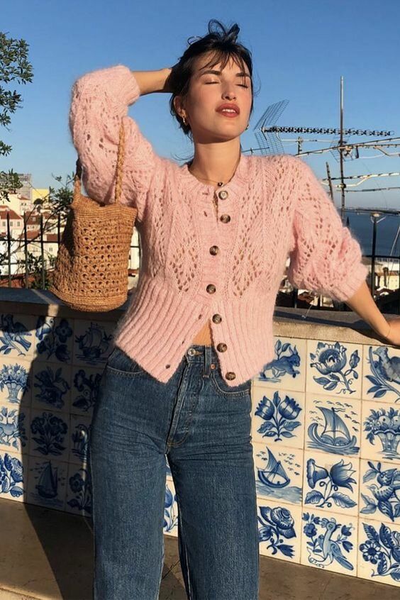 a beautiful vintage-inspired outfit with a blush vintage crochet cardigan as a top, navy jeans and a woven bag