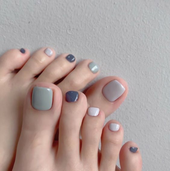 a delicate pastel pedicure with all different nails - white, light green and grey ones is a lovely idea to rock
