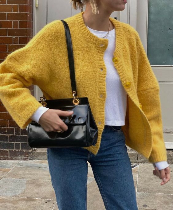 navy jeans, a white cropped t-shirt, a yellow cropped cardigan and a black bag are a great combo for the fall