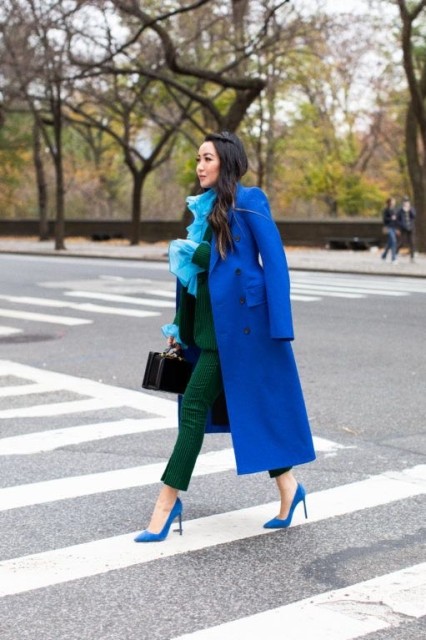 With light blue ruffled blouse, black bag and blue pumps