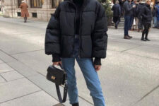 With sunglasses, blue cropped jeans, black leather mid calf flat boots and black leather mini bag