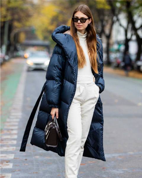 With white pants and black and white leather bag