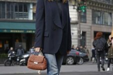 a Parisian-style fall look with a grey turtleneck, an oversized navy blazer, blue jeans, black boots and a catchy bag