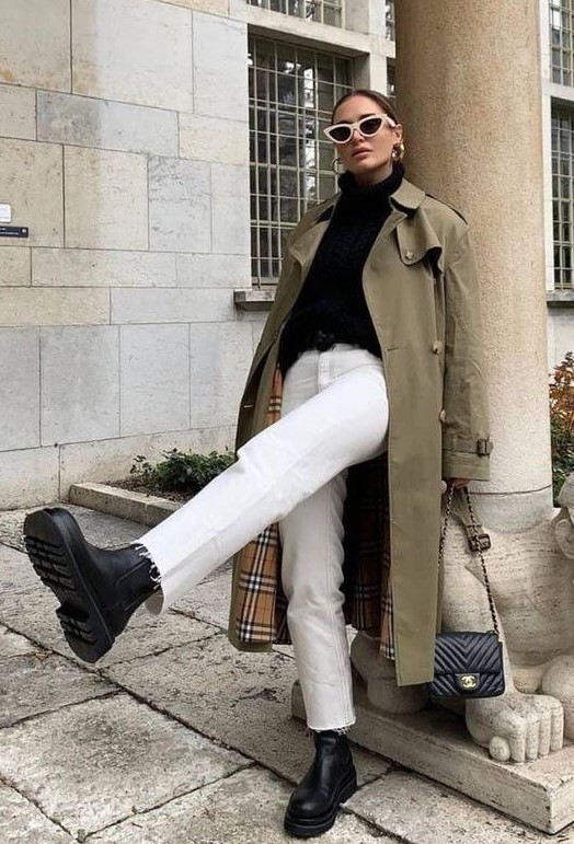 a black turtleneck, white jeans, black chunky boots, a green trench and a black bag plus statement earrings